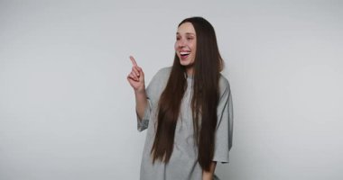 Genç bir kadın gülümseyen bir şekilde beyaz arka plan üzerine parlak bir fikir sunuyor.