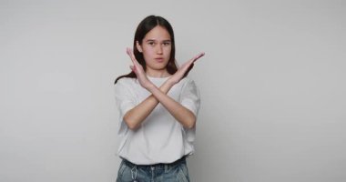 Kollarını sıkıca kavuşturan genç bir kadının güçlü ve kararlı bir duyguyu ışık arka planında ifade ettiği görüntüler.