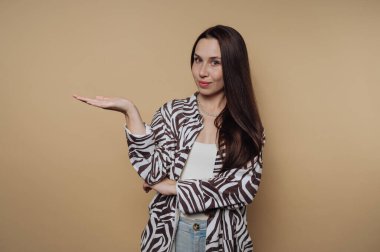 Zebra desenli tişörtlü kadın bej arka planda el kol hareketi yapıyor..