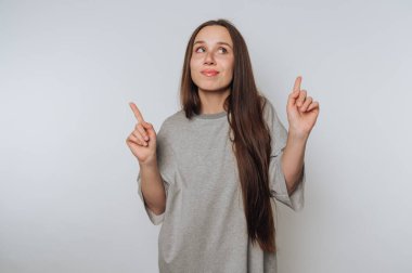 Genç kadın portresi sevinçle ışıldarken arka planda yukarıya bakıyor.