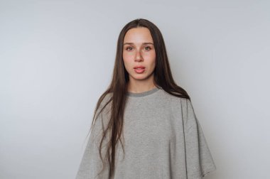 Genç bir kadının portresi parlak arka planda çarpıcı gözleri olan ciddi bir ifade gösteriyor.