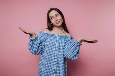 Genç bir kadının portresi pembe arka planda neşeli bir duruş sergiliyor.