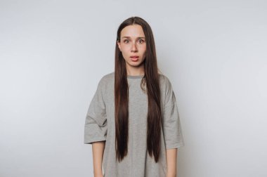 Genç bir kadının portresi hafif arka planda dururken şaşırmış bir ifade takınır.