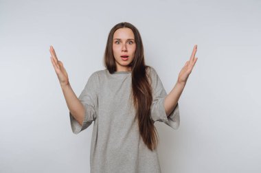 Endişeli genç bir kadının portresi, arka plandaki el hareketleriyle inançsızlığını gösterir.