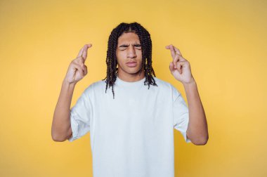 Genç adamın portresi, umut dolu parmaklar ve sarı arka planda beklenti taşıyor.