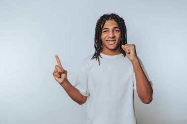 Genç bir adamın portresi bir yumrukla başarıyı kutluyor, arka plandaki başarının sevincini somutlaştırıyor.