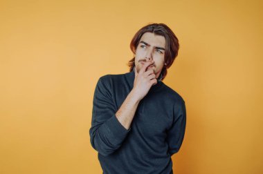 Genç adamın portresi düşünceli bir duruşta, özenle sarı arka plana bakıyor.