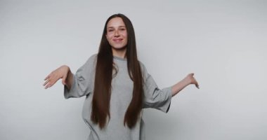 Neşeli bir kutlama için kollarını kaldıran genç bir kadının görüntüleri, arka planda saf mutluluğu sergiliyor.