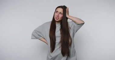 Kafasını kaşıyan uzun saçlı, kafası karışmış bir kadın.