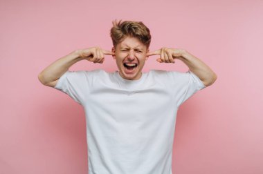 Pembe arka planda kulakları olan beyaz gömlekli bir adam..