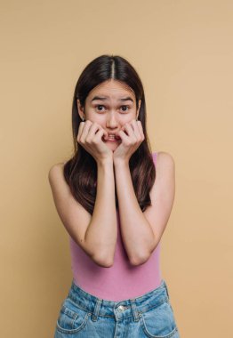 Bej bir geçmişi olan endişeli bir yüzü olan genç kadın..