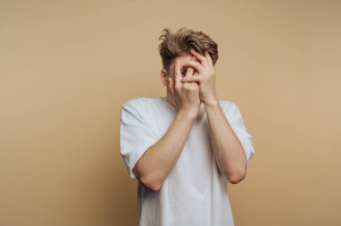 Bir insan, görünürde üzgün ve elleriyle yüzünü gizleyen basit, tarafsız bir odada duruyor. Görünüşü gündüz gözüyle bir bunalım ya da sıkıntı anı olduğunu gösteriyor..