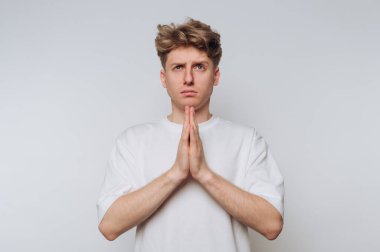Beyaz gömlekli genç adam, elleri dua pozisyonunda, tarafsız bir geçmişi var..