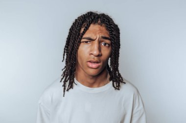 Rastalı genç adam karışık bir ifade takınıyor..