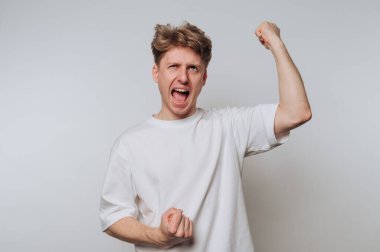 Beyaz gömlekli bir adam heyecanını yumruklarıyla dile getiriyor..