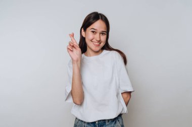 Uzun saçlı, gülümseyen bir kadın bir elinde şans diliyor..