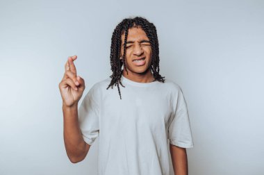 Saçları örgülü, beyaz tişört giyen genç bir adam. Geçmişinde umut veya şans olduğunu söylüyor..