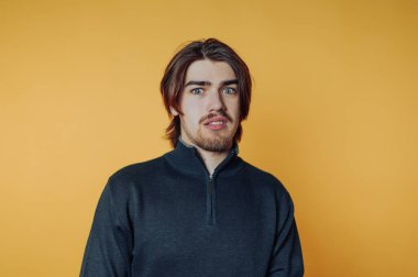 Sarı arka plana şaşırmış genç bir adam..