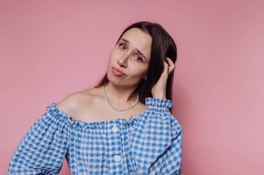 Kafası karışmış mavi omuzlu bir kadın..