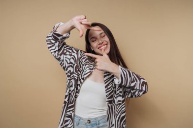 Gülümseyen kadın bej arka planda elleri olan çerçeveli kadın..