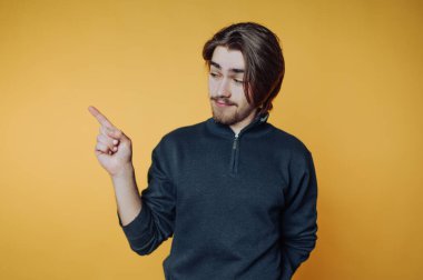 Sarı arkaplanı gösteren uzun saçlı genç adam..