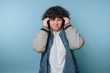 Kot ceketli kıvırcık saçlı biri hayal kırıklığına uğramış görünüyor..