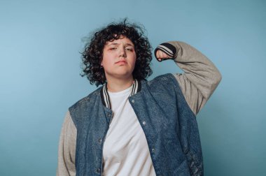 Kot ceketli kıvırcık saçlı, esnek kollu biri..