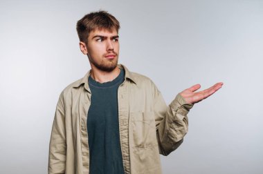 Kafası karışmış genç bir adam elini uzatıyor..