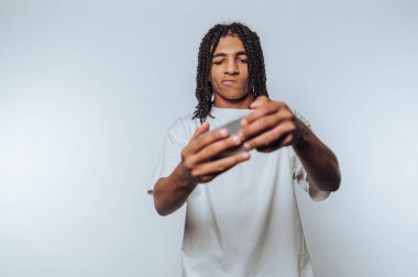 Rastalı genç adam akıllı telefonuyla selfie çekiyor..