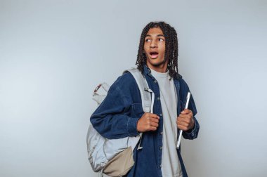 Sırt çantası ve tabletli genç şaşırmış görünüyor..