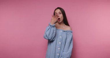 footage of young woman playfully blows a kiss, highlighting joy and charm on pink background