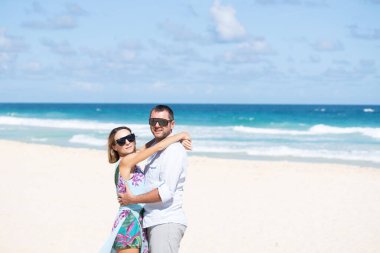 Güzel bir sahilde öpüşen güzel insanlar.