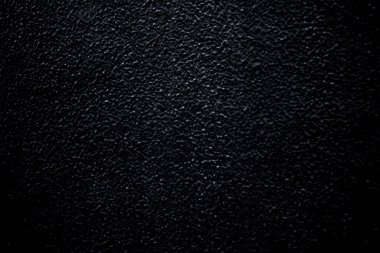 Photo of a black painted wall with pimples