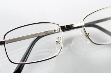 Beyaz arkaplanda metal çerçeveli gözlük