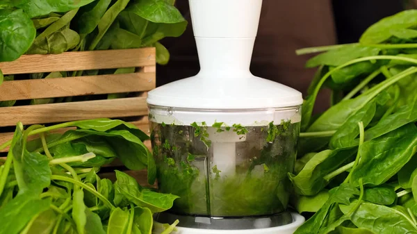 Spinach smoothie. The process of making smoothies in a blender from green spinach leaves. Concept of healthy eating, fitness food menu, healthy lifestyle, diet slow motion close-up