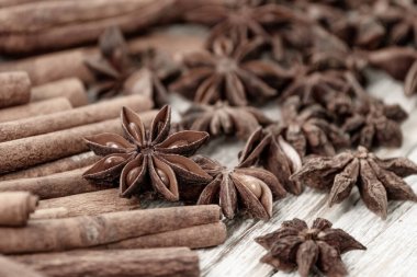 Background with cinnamon sticks, anise stars, coffee beans and nuts. Spicy trendy background. Close-up of various spices on wooden table top view