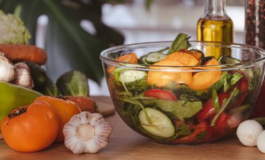 Salata. Domatesli taze sebze salatası, salatalık, soğan ve zeytinyağı. Sağlıklı yiyecekler. Vejetaryen diyeti. Evde mutfakta sebze salatası yapmak, sebzeleri yakın plan kesmek.