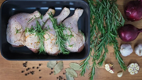 Preparing chicken drumsticks for roasting or stewing. Puts chicken legs in baking dish. Cooking baked chicken. Prepare chicken marinated meat for the cooking in oven. Flat lay, Top view