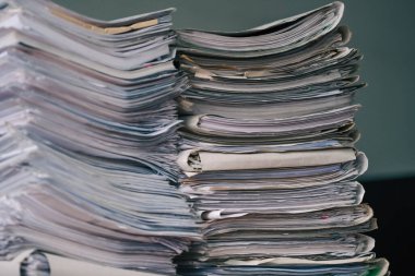 İçerideki ahşap masada şarjörlü boş kağıtlar yığını. İş yeri. Bir sürü belge, kontrat, yasal anlaşmalar, çalışma masasındaki kağıtlar. İş kavramı, çalışma, Jo