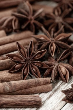 Background with cinnamon sticks, anise stars, coffee beans and nuts. Spicy trendy background. Close-up of various spices on wooden table top view