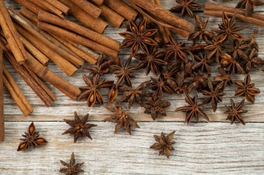 Background with cinnamon sticks, anise stars, coffee beans and nuts. Spicy trendy background. Close-up of various spices on wooden table top view