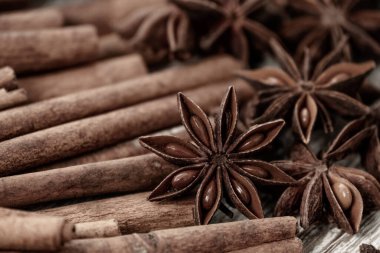 Background with cinnamon sticks, anise stars, coffee beans and nuts. Spicy trendy background. Close-up of various spices on wooden table top view