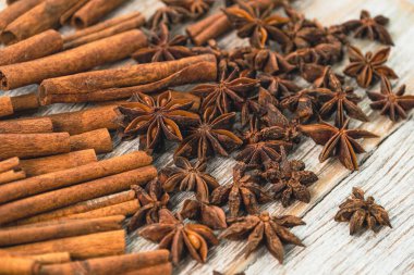 Background with cinnamon sticks, anise stars, coffee beans and nuts. Spicy trendy background. Close-up of various spices on wooden table top view