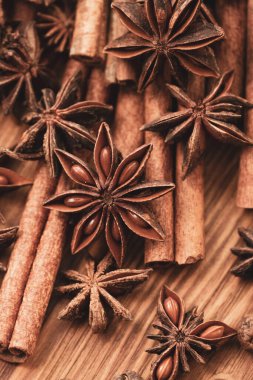 Background with cinnamon sticks, anise stars, coffee beans and nuts. Spicy trendy background. Close-up of various spices on wooden table top view