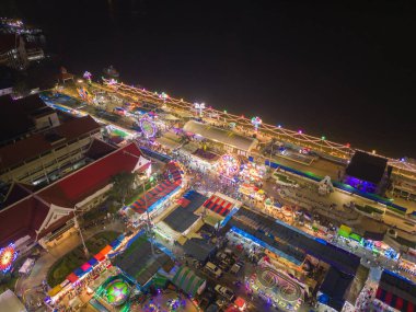 Gece tapınağındaki eğlence parkının hava manzarası ve gece pazarları. İnsanlar Bangkok, Tayland 'da renkli çadırlarda yürüyor. Perakende mağazaları