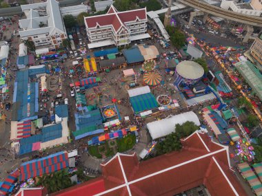 Gece tapınağındaki eğlence parkının hava manzarası ve gece pazarları. İnsanlar Bangkok, Tayland 'da renkli çadırlarda yürüyor. Perakende mağazaları