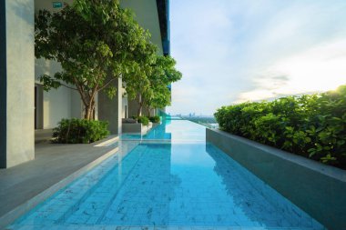 Bangkok şehir merkezindeki apartmanın çatısında yüzme havuzu, şehir manzarası. Tatil tatili konseptinde yaz sezonunda dinlenmek. Eğlence yaşam tarzı.