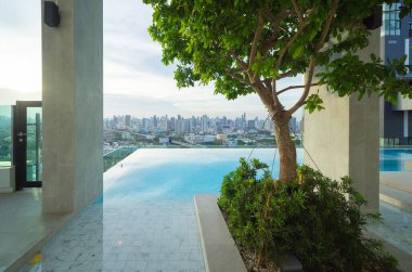 Bangkok şehir merkezindeki apartmanın çatısında yüzme havuzu, şehir manzarası. Tatil tatili konseptinde yaz sezonunda dinlenmek. Eğlence yaşam tarzı.