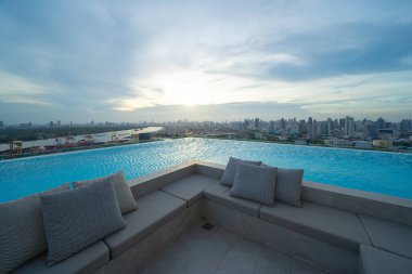 Bangkok şehir merkezindeki apartmanın çatısında yüzme havuzu, şehir manzarası. Tatil tatili konseptinde yaz sezonunda dinlenmek. Eğlence yaşam tarzı.