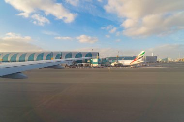 Bir uçak jetinin uçuş ve iniş kanadı, havaalanındaki pist penceresinden kentsel şehir manzaralı binalar. Seyahat ve ulaşım kavramı.